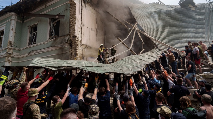 Workers remove debris from a destroyed hospital 